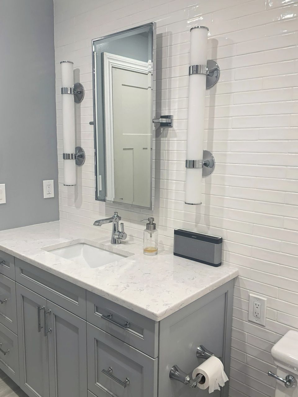 Bath vanity with a shiplap wall and tall sconces