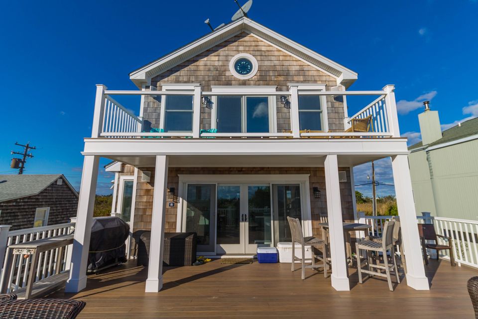 Rear of a beach house with a balcony over a deck