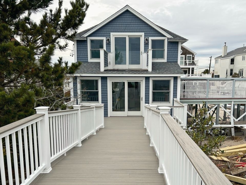 Beach house with blue siding, a ramp, and a deck