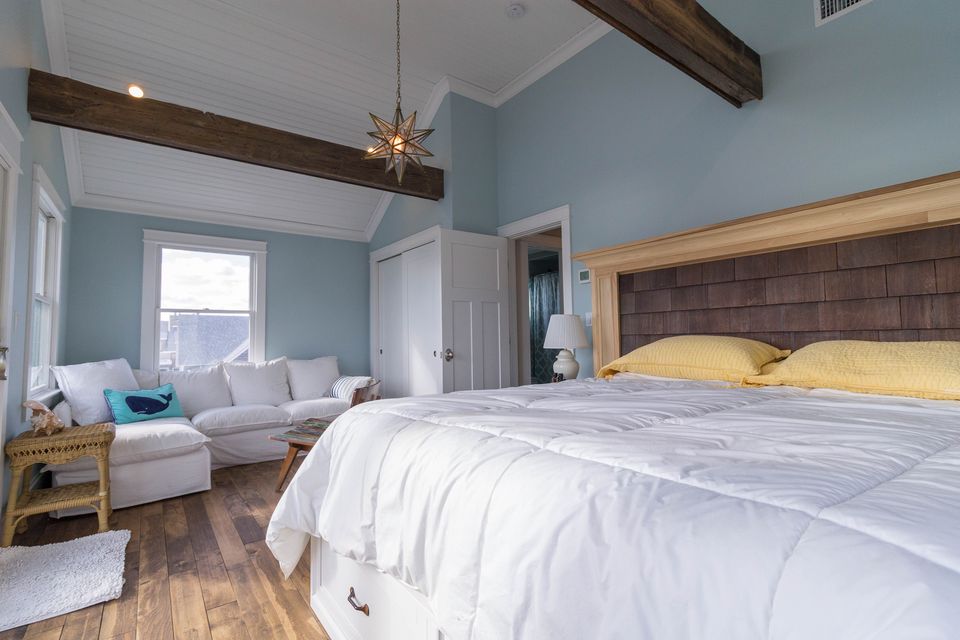 Bedroom with blue walls, a timber beam, and a shingle headboard