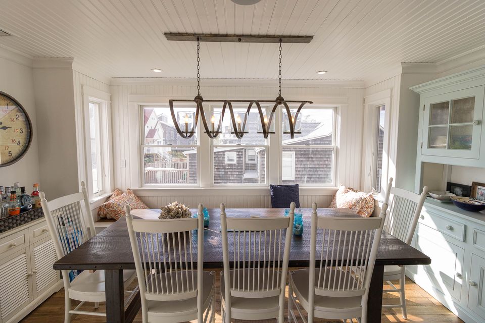 Breakfast nook with a built in bench, farm table, and iron pendant