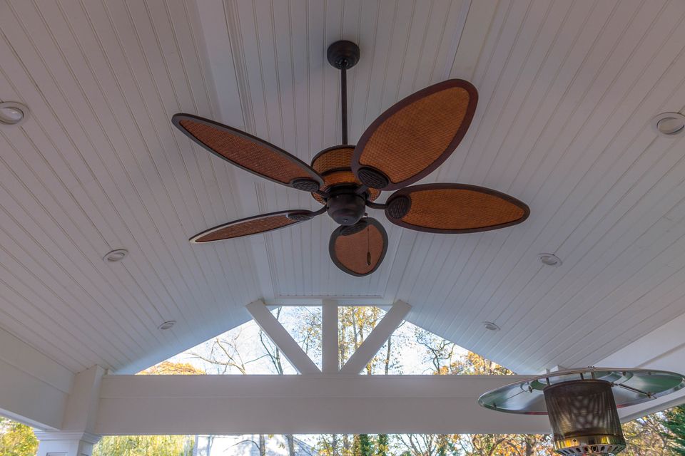 Vaulted beadboard ceiling with a fan over a covered patio