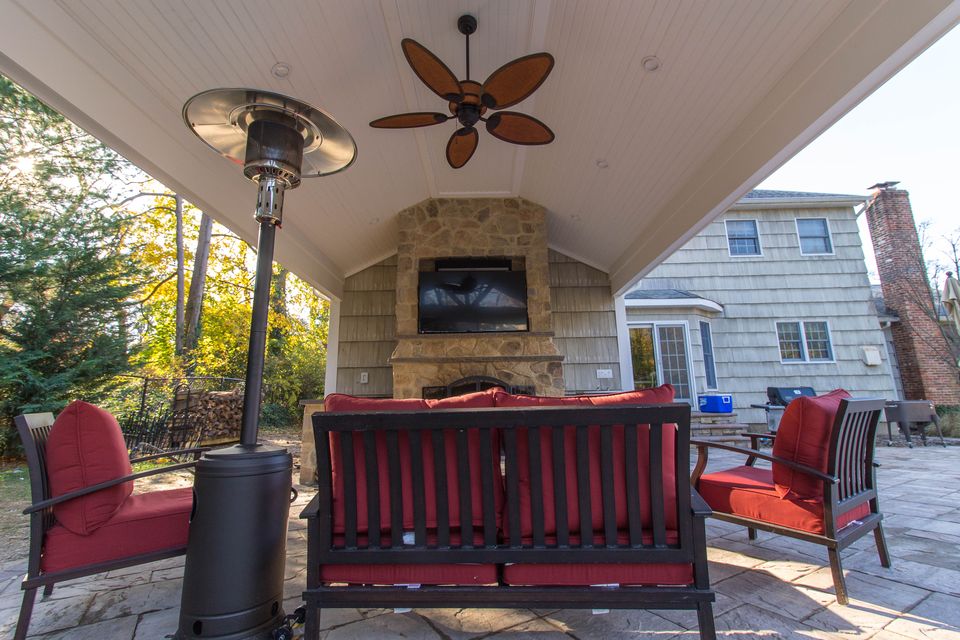 Covered patio with an outdoor fireplace, TV, and heater