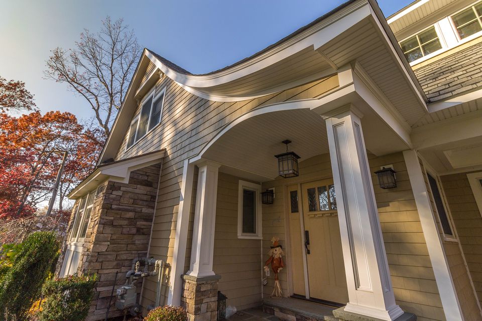 Craftsman portico with a curved gable and tapered columns