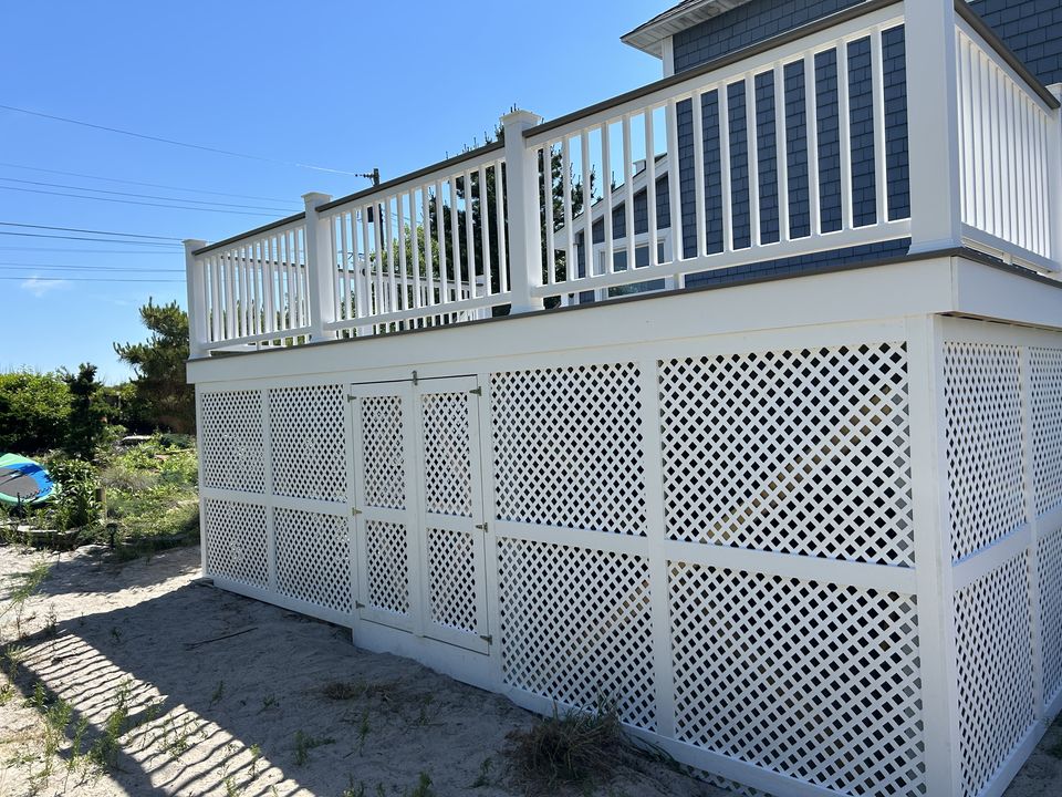 Side of a raised deck with white rails and lattice skirting