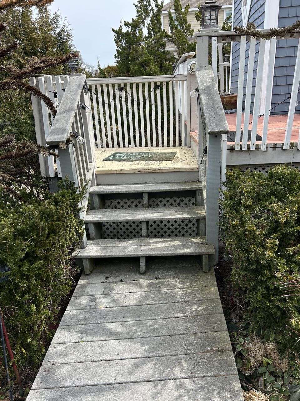 Before: weathered wood stair and rails at the end of a garden walkway