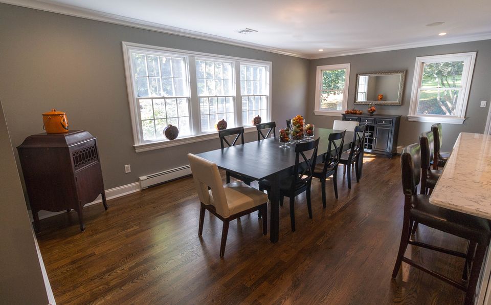 Dining room with a bar counter, dark wood floors, and a wall of windows