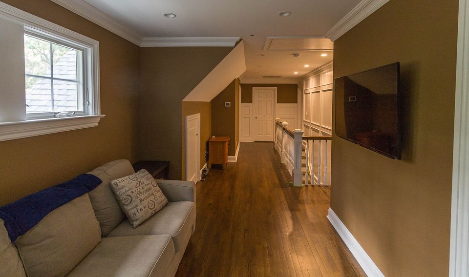 Family room opening to a hall with wood floors