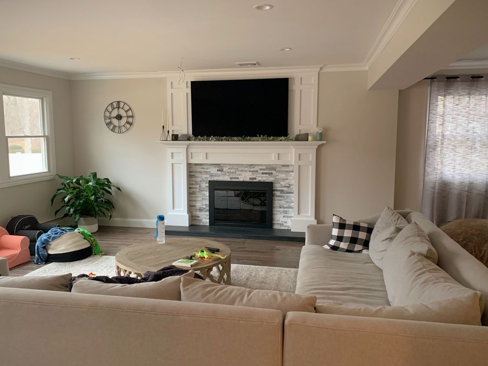 Family room with a stone fireplace and white mantel