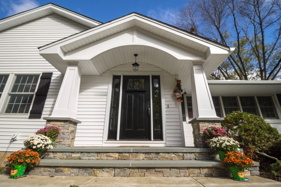 Front portico with an arched ceiling, square columns, and stone steps