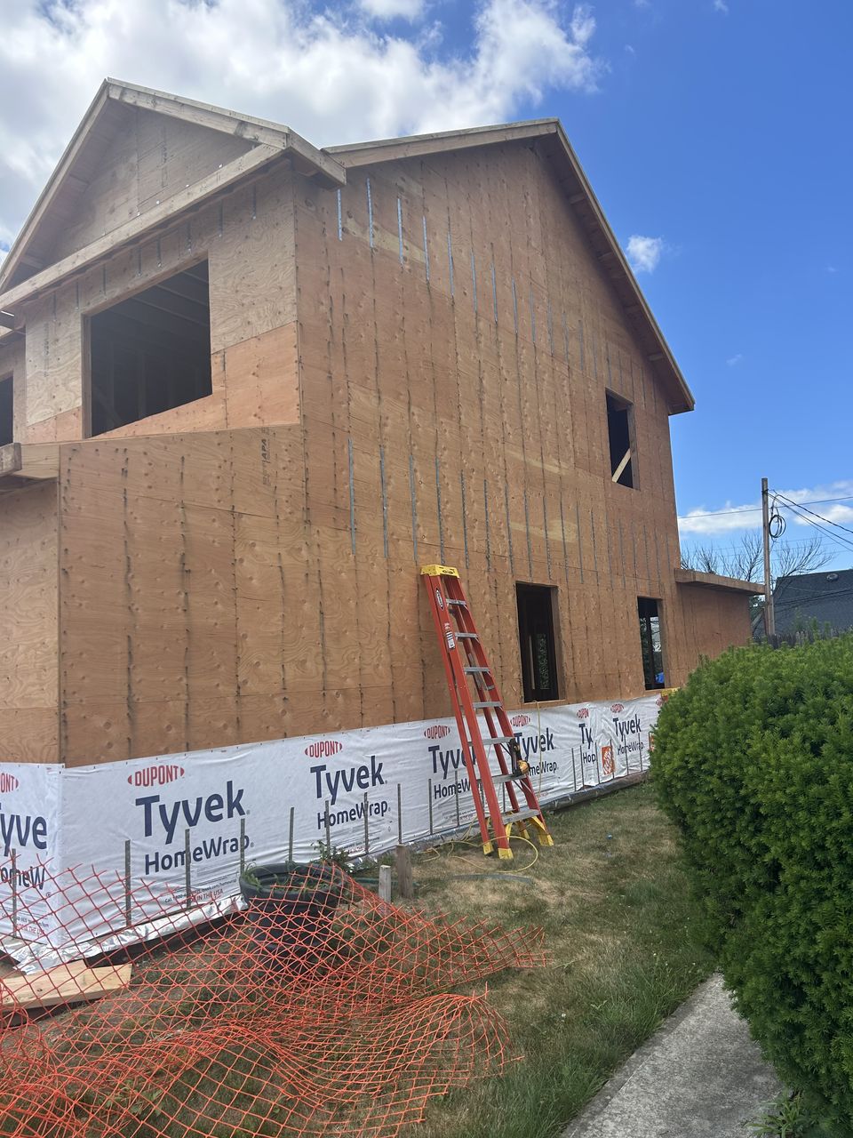 Two story new build in plywood sheathing, with house wrap along the base