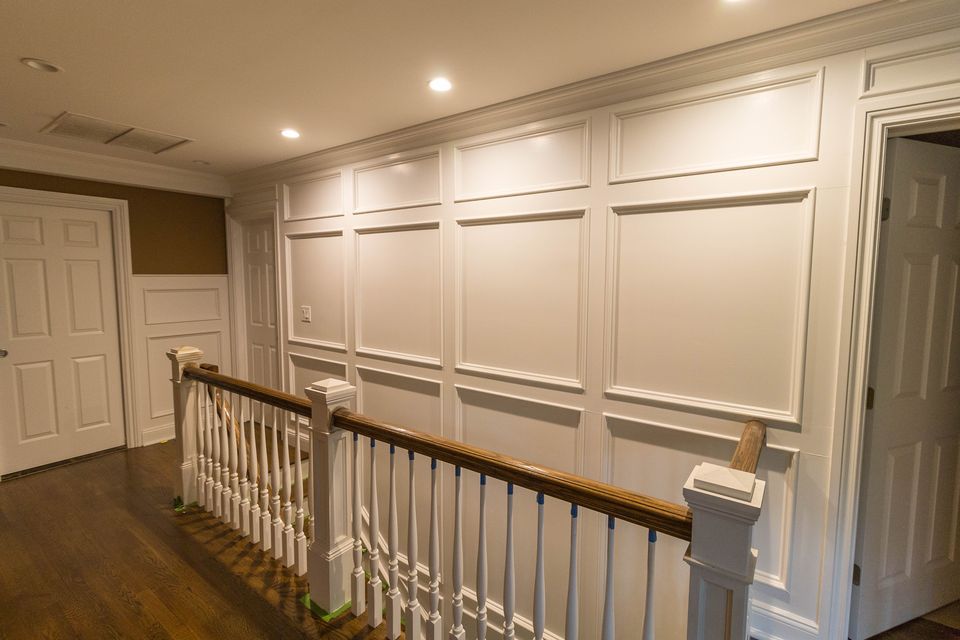 Upstairs hall with raised panel wainscoting and a railing