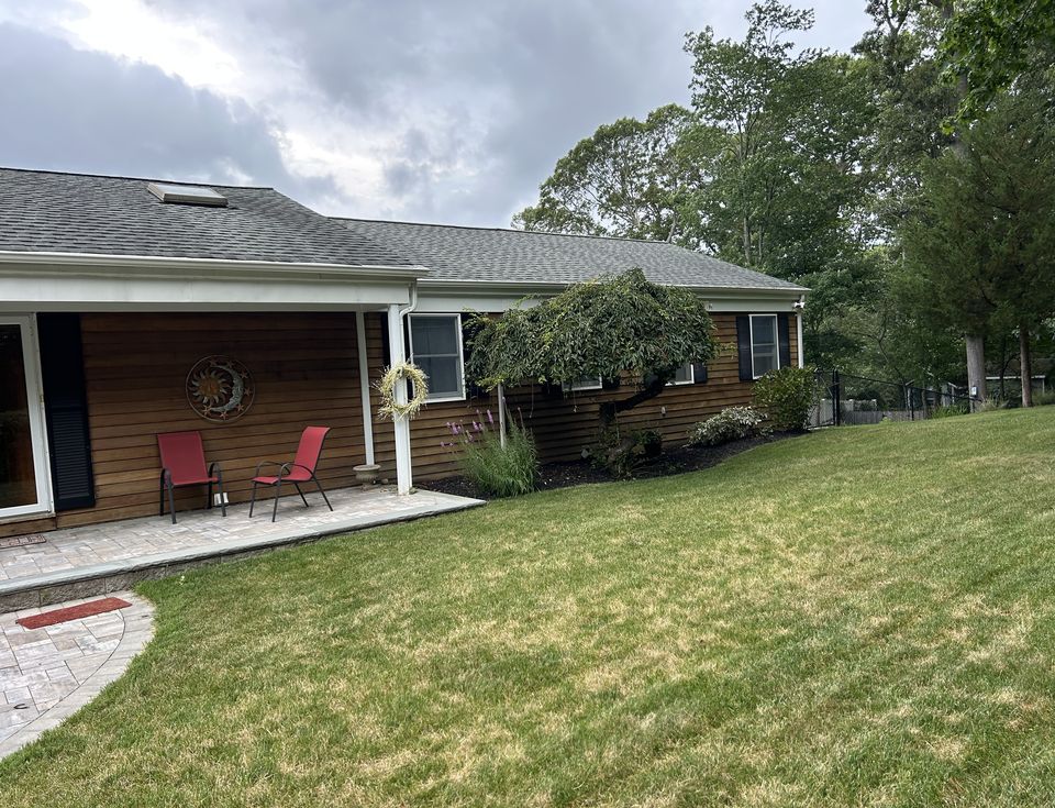 Paver patio and walk along a cedar sided ranch
