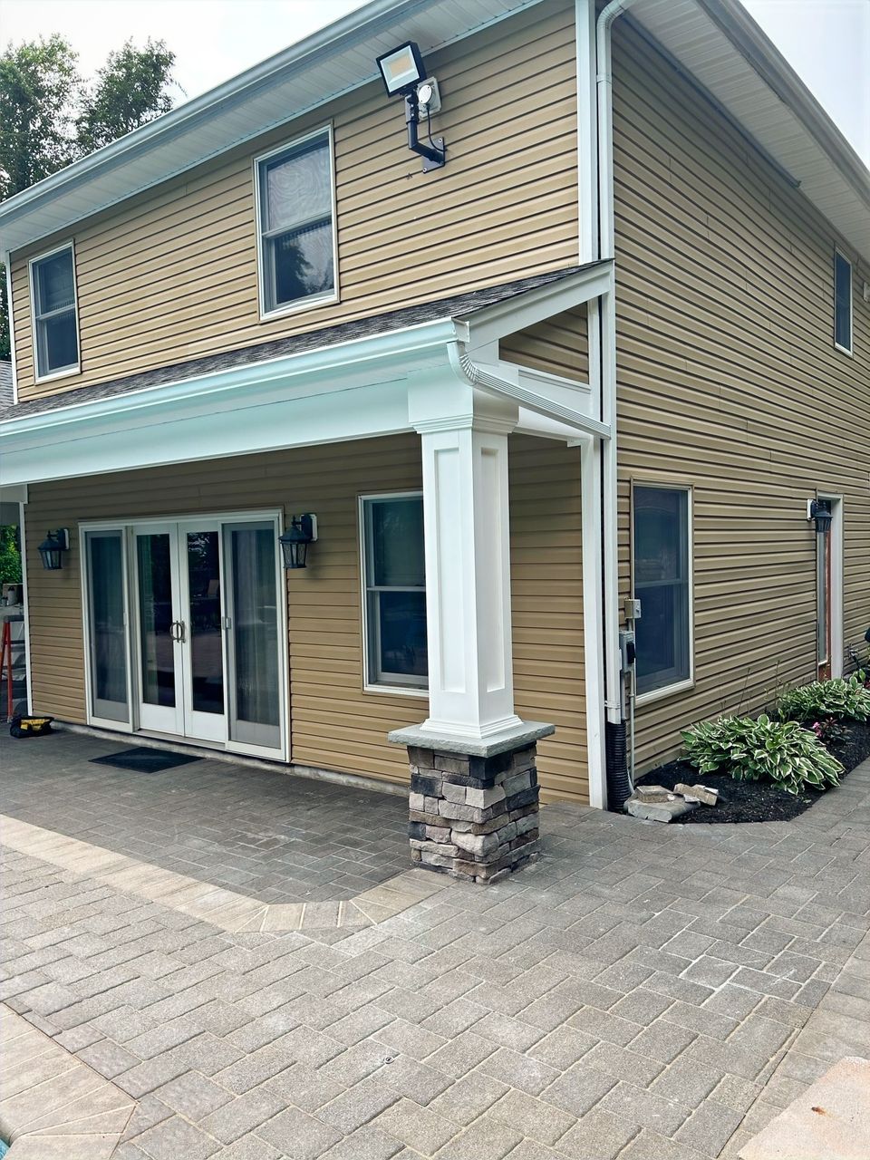 Rear addition with columns, French doors, and a paver patio