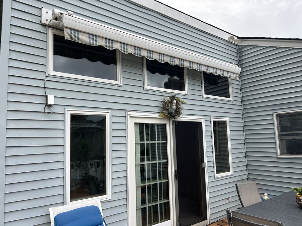 Rear doors and windows in blue siding opening onto a patio