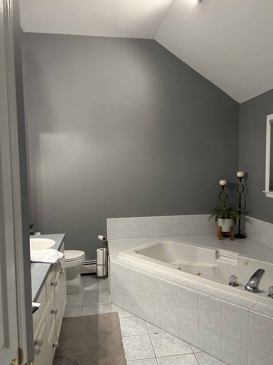 Before: primary bath with a corner tub under a sloped ceiling