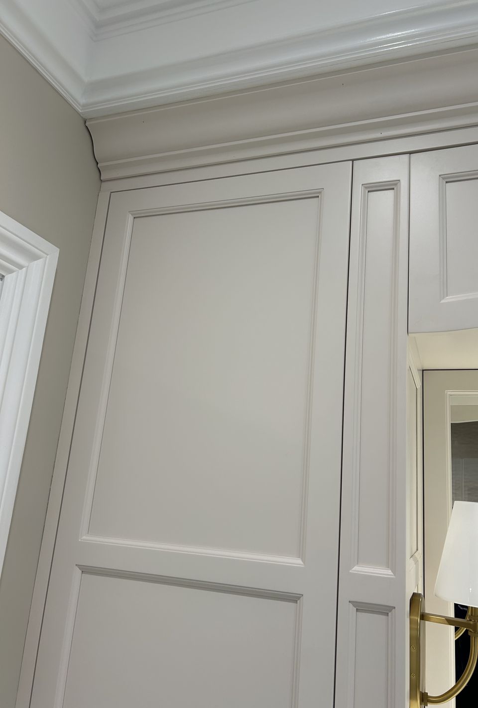 Built in linen cabinet with raised panel doors and crown molding