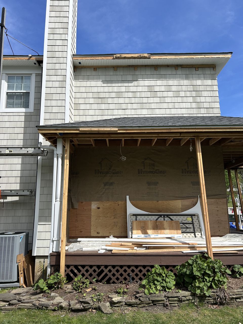 Covered porch framed and sheathed next to the new cedar shake