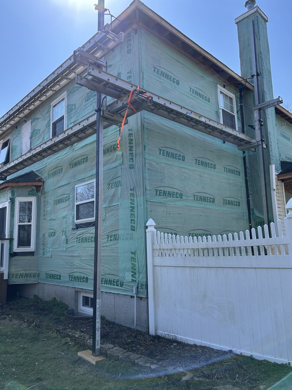 Side of the house in house wrap with staging up