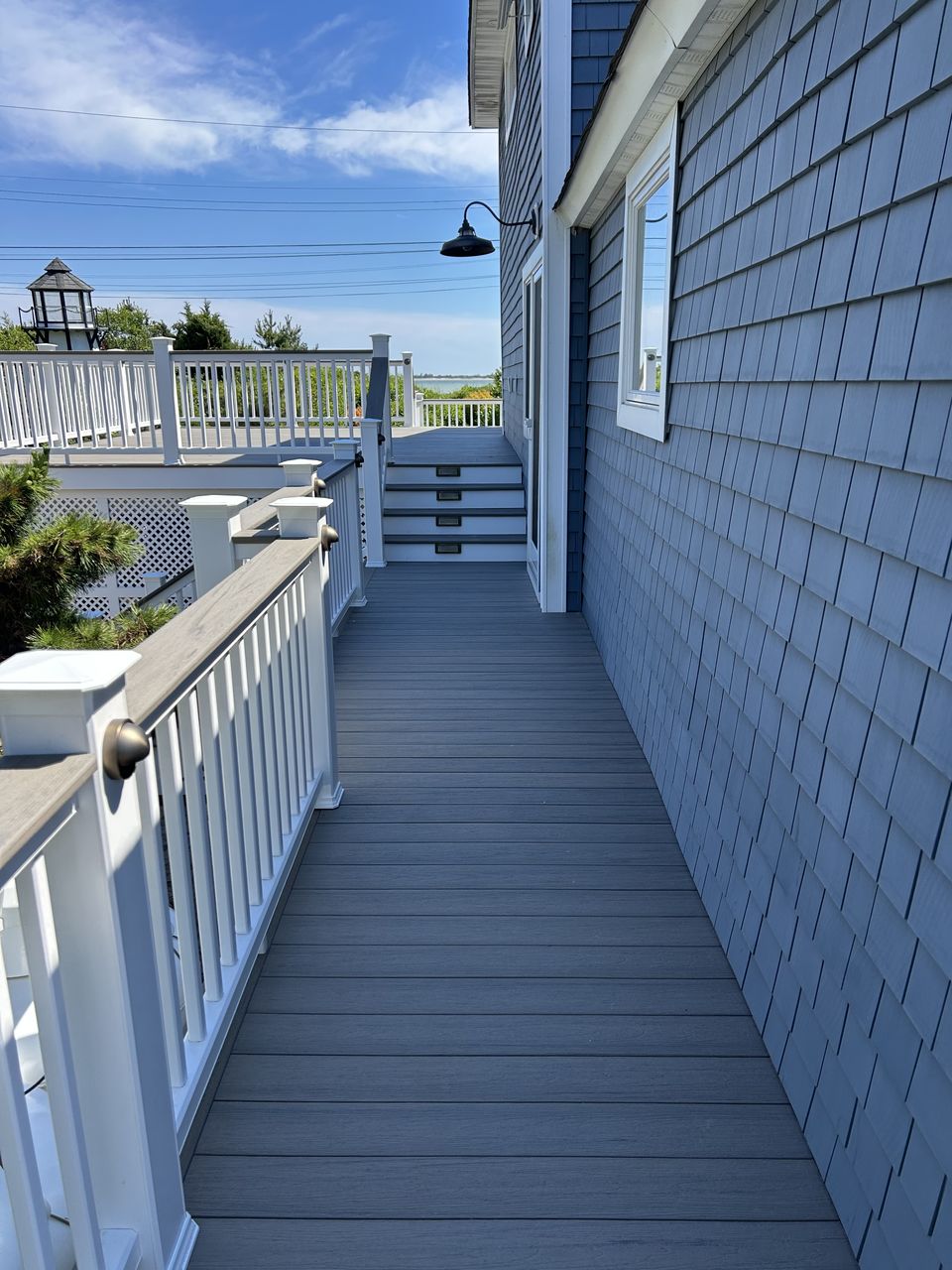 Deck walkway along a shingle wall leading to another set of stairs
